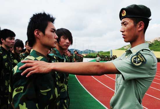 沈阳军区雷锋班副班长徐铭晨在给山东红足—世足球网大一新生进行军训
